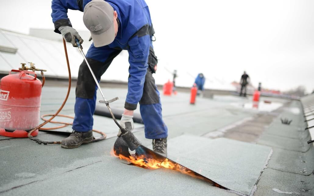 Men applying new flat top roof coating