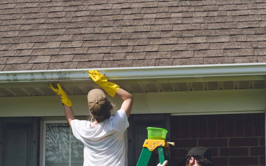 Residential gutters being cleaned on a house