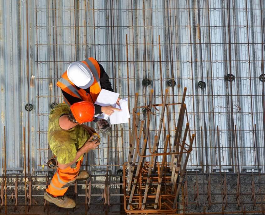 Two men overhead looking at checklist as they conduct a pre-construction roof inspection